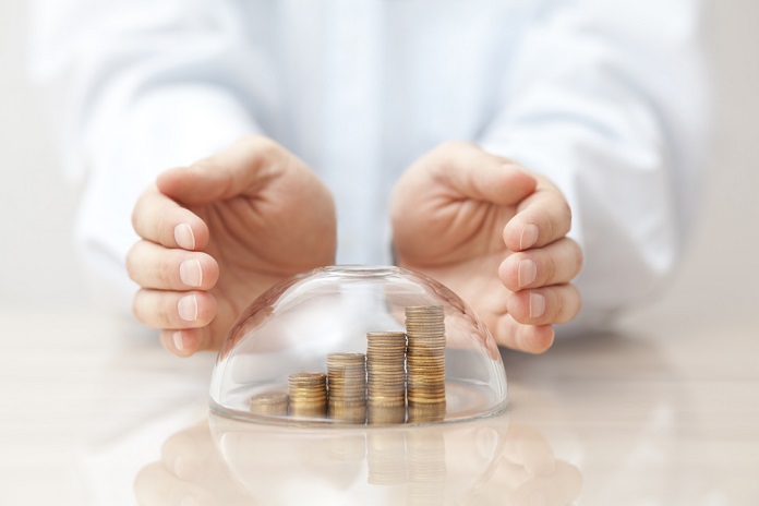 Women Rising coins protected under a glass dome and hands refer the value of life insurance for kids